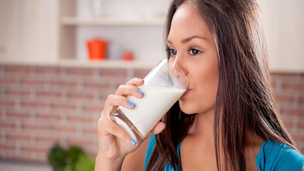 年轻女子喝牛奶的特写镜头