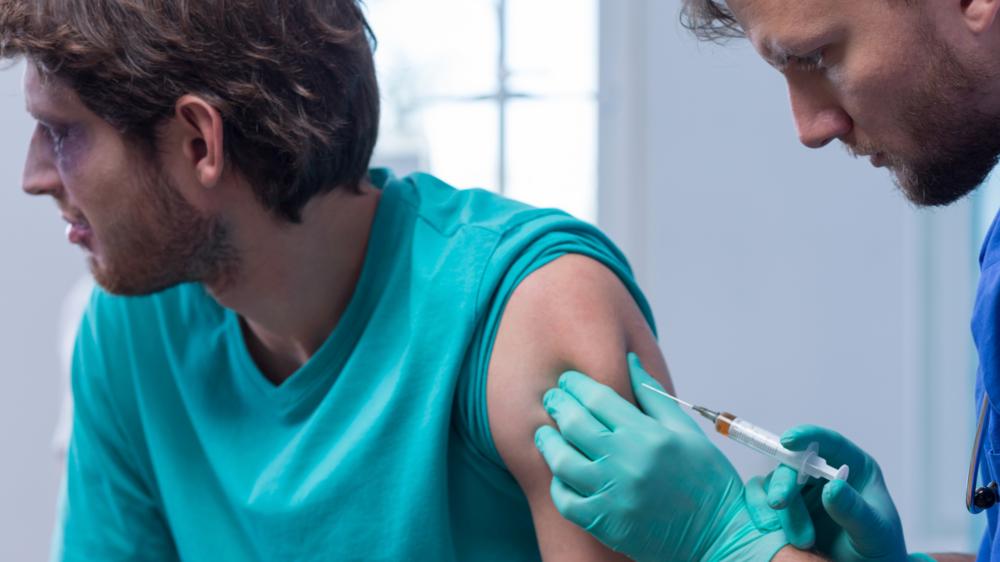 一个男人从男医生接受疫苗接种